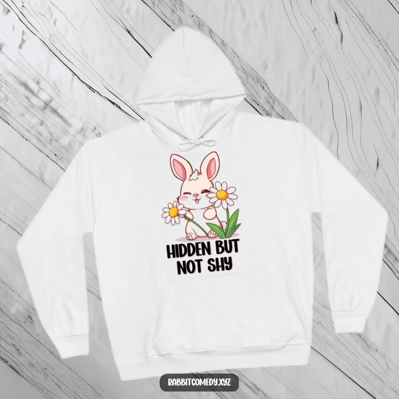 Funny hoodie featuring a mischievous rabbit winking from behind a laughing daisy, offering warmth and playful spirit.
