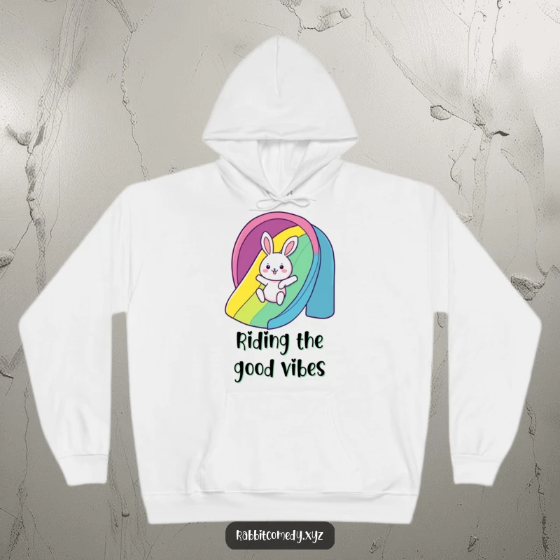Funny Hoodie: A kawaii rabbit gleefully slides down a rainbow, offering a humorous and cozy reminder of pure fun.